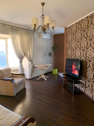a living room with a tv and a couch and a table at Great apartment in the city centre in Ivano-Frankivsʼk