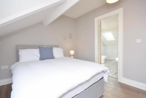 a bedroom with a large white bed and a window at Queens Quarter Townhouse 2 in Belfast