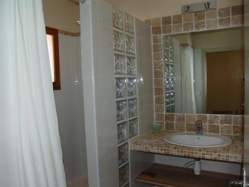 a bathroom with a sink and a mirror at Les Hauts de Pinarello in Sainte-Lucie de Porto-Vecchio
