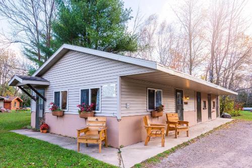a small white house with chairs and a table at Spur of the Moment Ranch in Mountain
