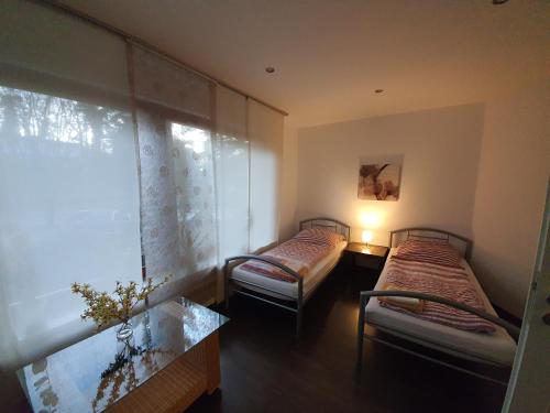 two twin beds in a room with a window at Apartment bei Hamburg bis 10 Personen mit Terasse und Gartennutzung. in Buchholz in der Nordheide
