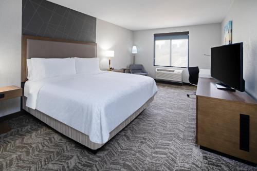 a hotel room with a large bed and a flat screen tv at Best Western Valencia/Six Flags Inn & Suites in Santa Clarita
