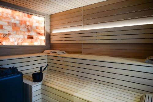 a sauna with wood paneling and a window at Les Jardins de Coppélia in Pennedepie