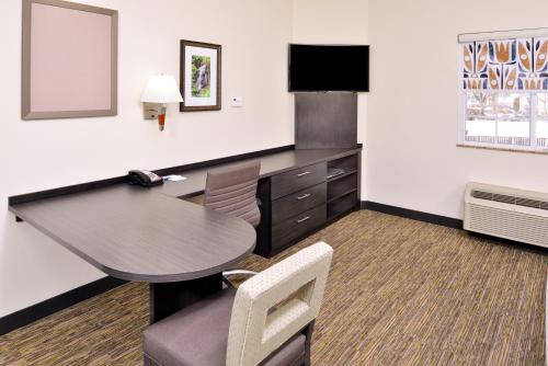 a hotel room with a desk and a table and chairs at Candlewood Suites Winchester by IHG in Winchester