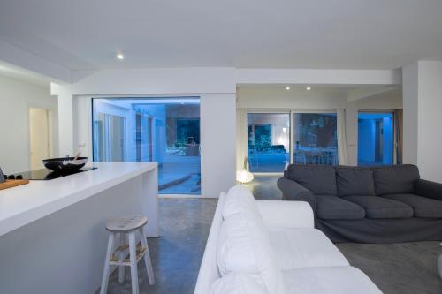 a living room with a white couch and a kitchen at Villa Mavrades in Sivota