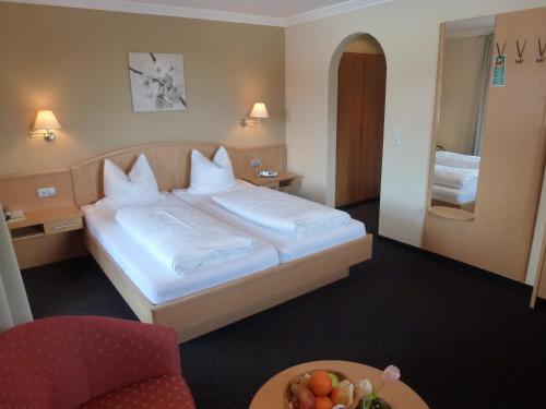 a hotel room with a bed and a table at Alpenhof Landhotel Restaurant in Oberaudorf