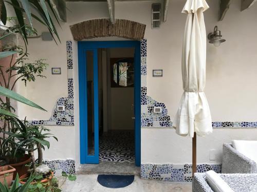 Una puerta azul en una habitación con sombrilla en Cortile Azzurro en Trapani