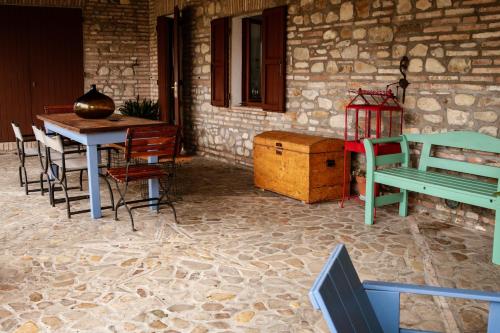 een patio met een tafel en stoelen en een tafel en een gebouw bij il mulino in Santarcangelo di Romagna