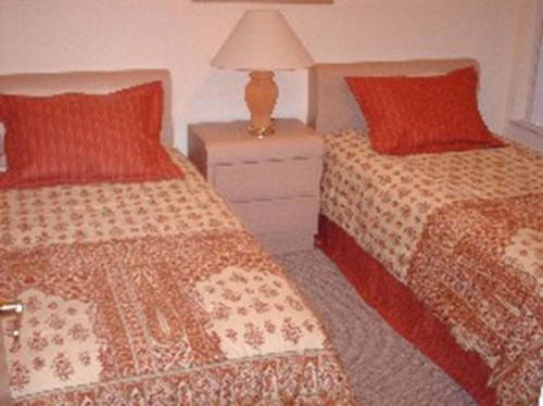 een slaapkamer met 2 bedden en een lamp op een nachtkastje bij Royal Palm Villa in Kissimmee