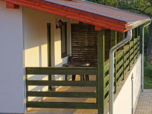 a deck with a wooden railing and a roof at Kisrejtek Apartmanház in Lispeszentadorján