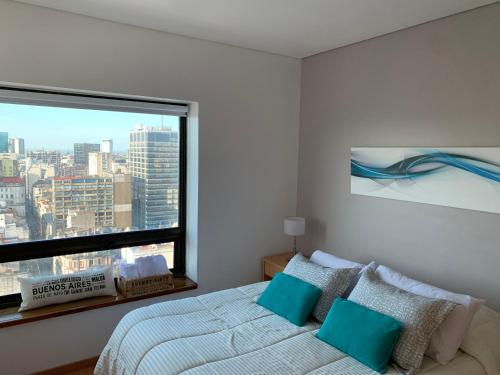 a bedroom with a bed and a large window at Buenos Aires View - Apart 2 Amb sobre Av Corrientes in Buenos Aires