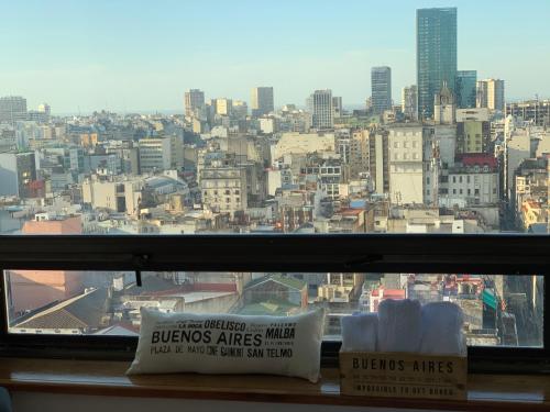 una ventana con vistas a la ciudad y 2 libros en Buenos Aires View - Apart 2 Amb sobre Av Corrientes en Buenos Aires