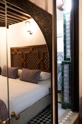 a bedroom with a canopy bed with a mirror at Le Grand Alcazar - Riad in Fès