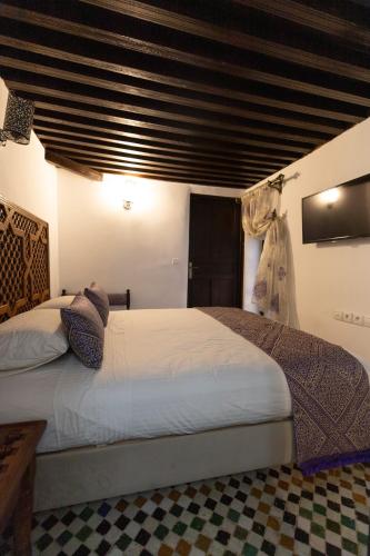 a bedroom with two beds and a large window at Le Grand Alcazar - Riad in Fès