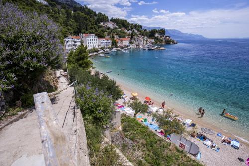 a beach with a group of people and the ocean at Family Beach Rooms in Omiš