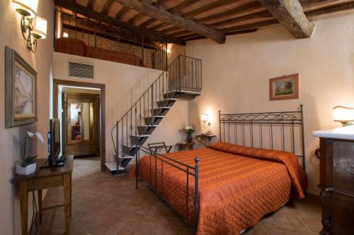 a bedroom with a bed and a spiral staircase at Camere Dentro Il Castello in Monteriggioni