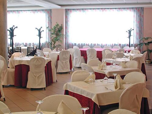 a dining room with white tables and white chairs at Hotel Miami in Civitella del Tronto