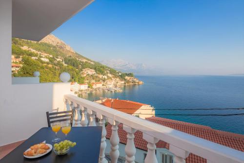 a balcony with a table with glasses of wine at Family Beach Rooms in Omiš