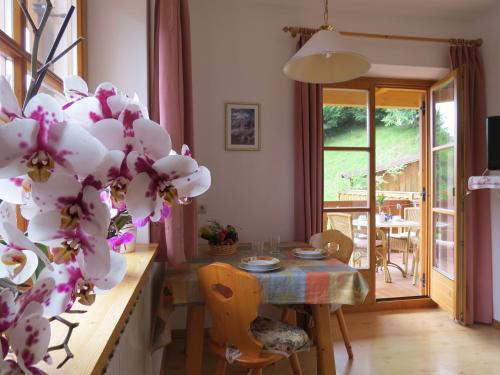 a kitchen with a table and a dining room with a plant at Agriturismo Kabishof in Funes