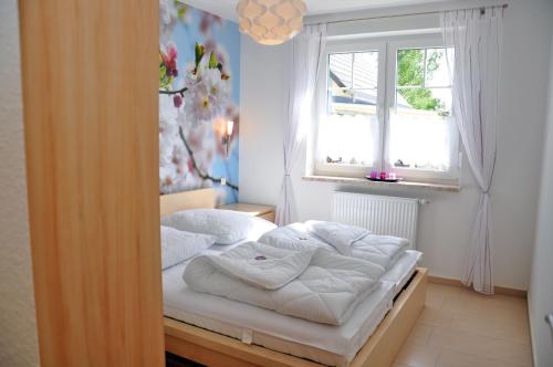 Cama en habitación con ventana en Ferienhaus Müritzsonne / EG-Appartement en Marienfelde