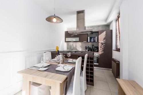 a dining room with a table and a kitchen at Apartments Bori in Poreč