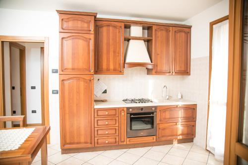 a kitchen with wooden cabinets and a stove at Oasi di pace nel sito UNESCO del Prosecco DOCG in Farra di Soligo