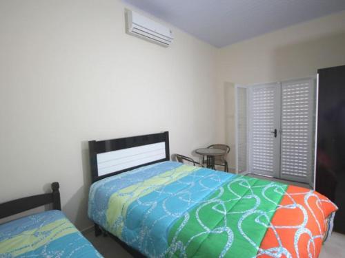 Un dormitorio con dos camas y una mesa y una ventana. en Pousada Kekanto, en Olímpia