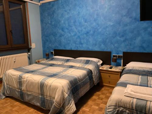 a bedroom with two beds and a blue wall at Casa Vacanza Nadia in Bergamo