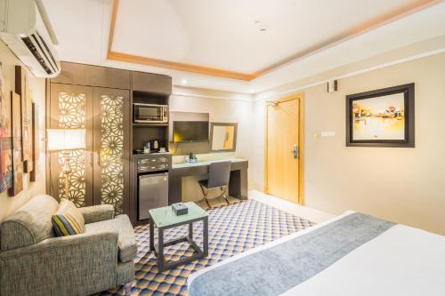 a hotel room with a bed and a living room at Al Muhaidb Residence Al Khobar in Al Khobar
