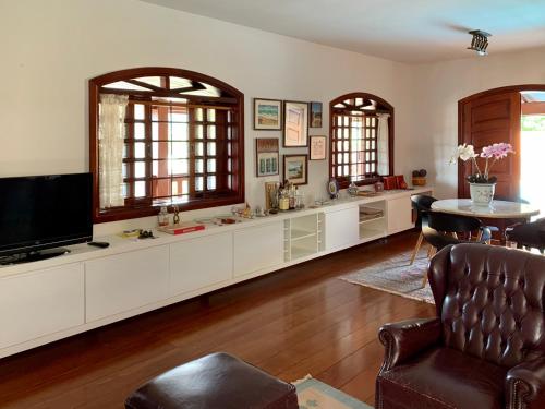 a living room with a tv and a couch and a table at Casa em Águas de Lindóia! in Águas de Lindoia