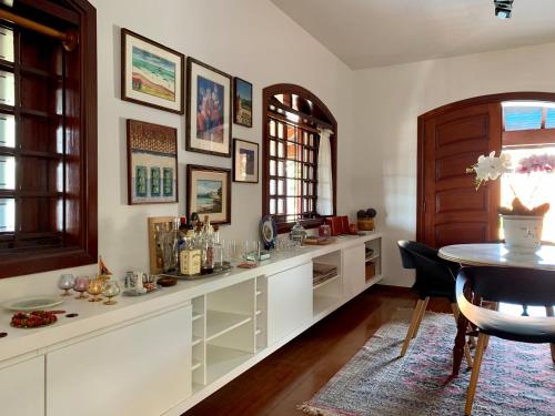 a kitchen with white cabinets and a table and a window at Casa em Águas de Lindóia! in Águas de Lindóia