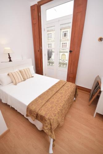 a bedroom with a bed and a large window at Pension La Corredera in Tui