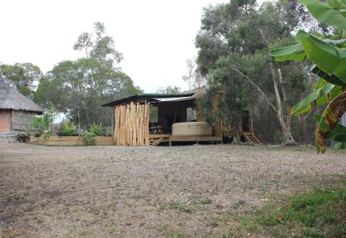 a small hut with a bed in a yard at La Case, un espace qui invite à l'essentiel ! in Bouloupari
