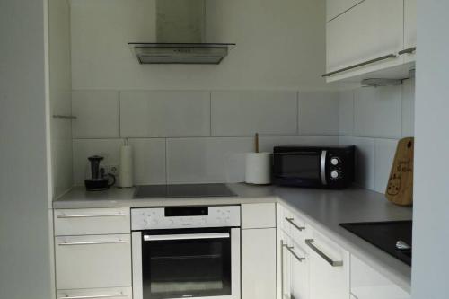 a kitchen with a stove and a microwave at Modernes Apartment Duisburg in Duisburg
