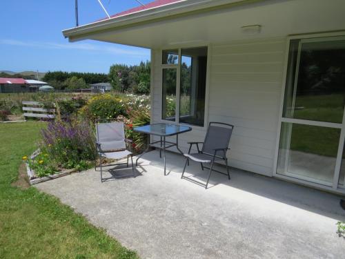 a patio with chairs and a table on the side of a house at waikawa house in Niagara