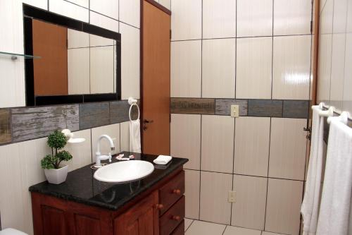 uma casa de banho com um lavatório e um espelho em Camping e Chalés Beira Mar em Maragogi