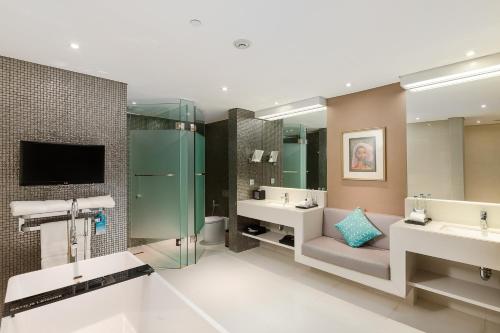 a bathroom with two sinks and a tv and two mirrors at Double - Six, Luxury Hotel - Seminyak in Seminyak