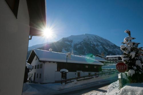 a snow covered building with a mountain in the background at Haus Resi in Berwang