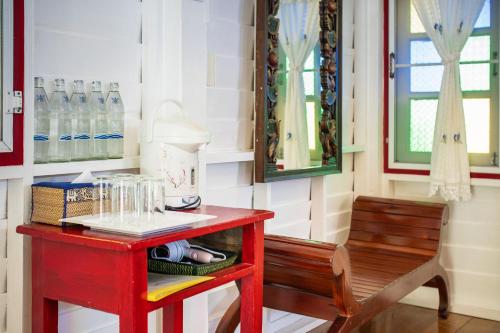 a red table and a chair in a room at Baan Imm Sook Resort in Chao Lao Beach