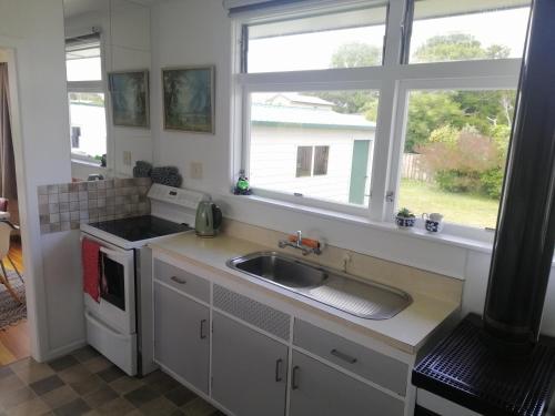 eine Küche mit einem Waschbecken und einem Fenster in der Unterkunft Super Central Cosy Greytown House with Garage in Greytown