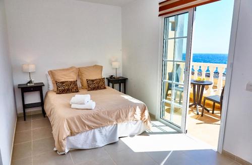 a bedroom with a bed with a view of a balcony at Medano Beach Villas in El Médano