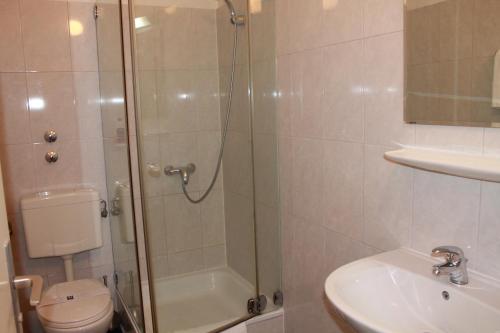 a bathroom with a shower and a toilet and a sink at City Hotel Mercator in Frankfurt/Main