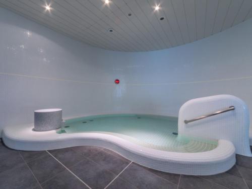 a bath tub in a white room with at LIBER HOTEL Osaka in Osaka