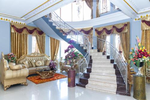 a living room with a staircase with blue walls at RedDoorz Premium @ Sea Residence Manado in Manado