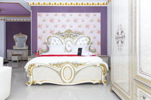 a bedroom with a king sized bed with purple walls at RedDoorz Premium @ Sea Residence Manado in Manado