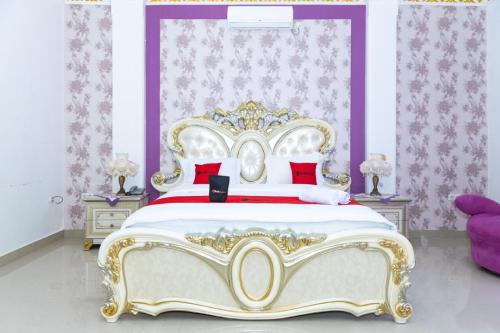 a bedroom with a king sized bed with red pillows at RedDoorz Premium @ Sea Residence Manado in Manado