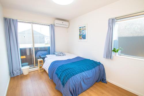 a bedroom with a bed and a large window at AMP FLAT Itoshima in Fukuoka