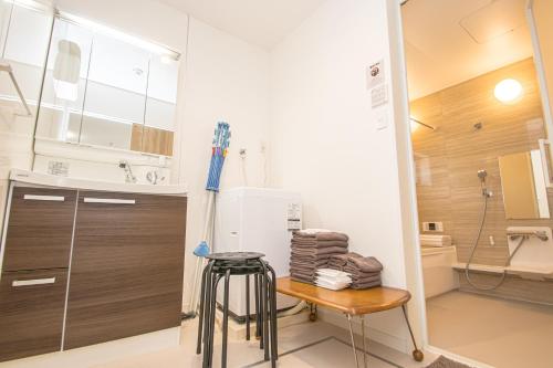 a small kitchen with a stool and a refrigerator at AMP FLAT Itoshima in Fukuoka