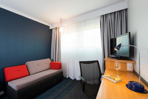 a living room with a couch and a television at Holiday Inn Express Birmingham Oldbury by IHG in Oldbury