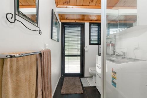 a bathroom with a sink and a toilet at Sandy Toes Holiday Home Orewa in Orewa